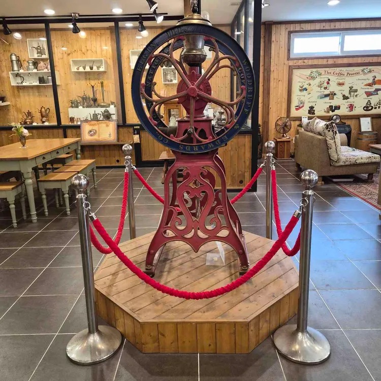 Antique red coffee grinder on its display platform