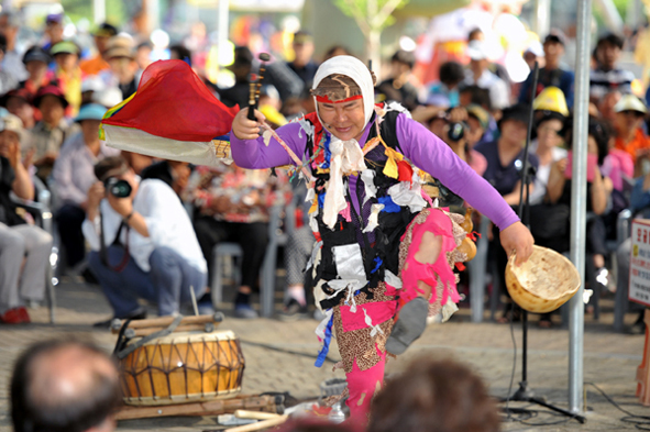 A pumba performer dancing with his gourd bowl before the crowd