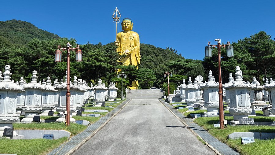 The 41m golden Jijang Bosal statue towering over the stupa path at Mitasa
