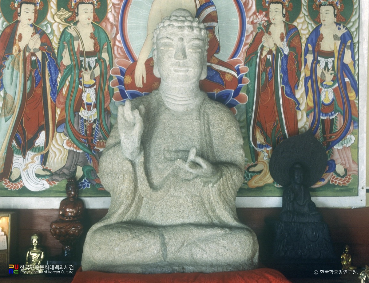 Stone seated Buddha of Mitasa before the altar painting